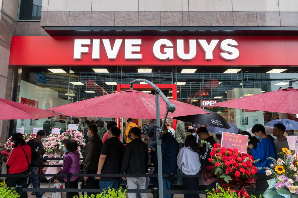 SHANGHAI, CHINA - APRIL 27: Customers wait to enter Five Guys restaurant on Middle Huaihai Road on April 27, 2021 in Shanghai, China. Five Guys opened its first restaurant in China on Monday. (Photo by Wang Gang/VCG via Getty Images)