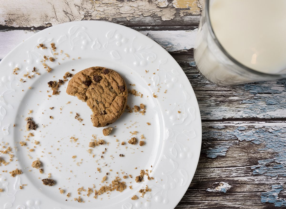 milk and cookies on a plate with crumbs